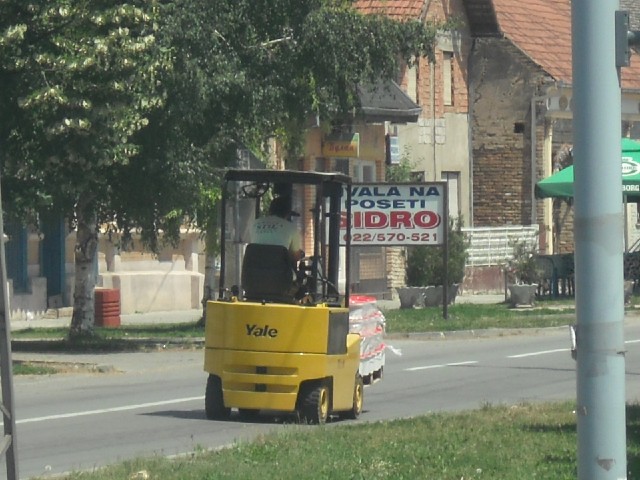 A pallet of water being taken down the road.