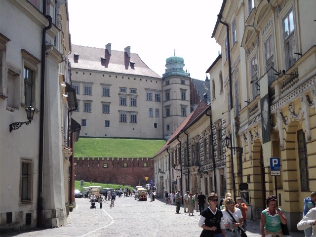Ahead is the Castle on Wawel Hill. On the right is a portrait of the young Archbishop Karol Wojtyla,...
