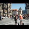 On the left, a bride and groom are having their photograph taken under Prague's Astronomical Clock.