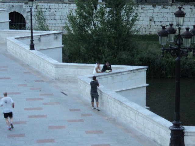 A bride and groom having their picture taken on the bridge.