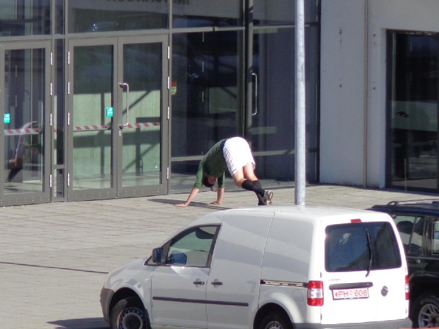 Somebody doing some stretches near a sports complex.