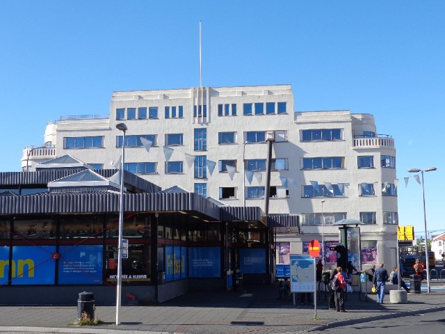 A deco building behind the bus station.