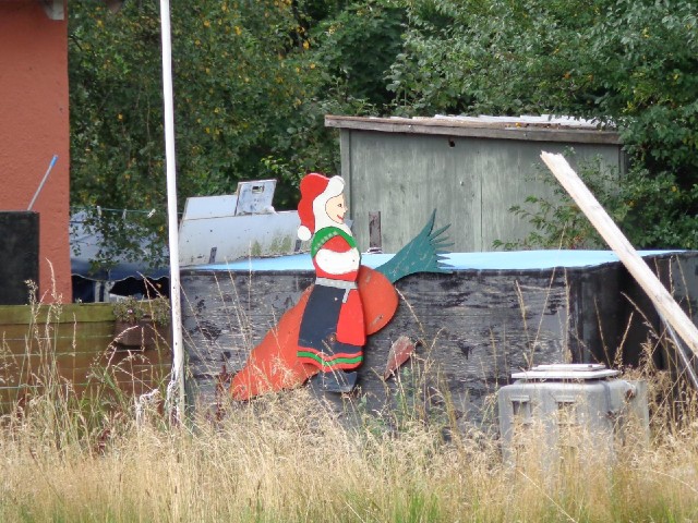 It appears to be Santa Claus in a dress riding a giant carrot.