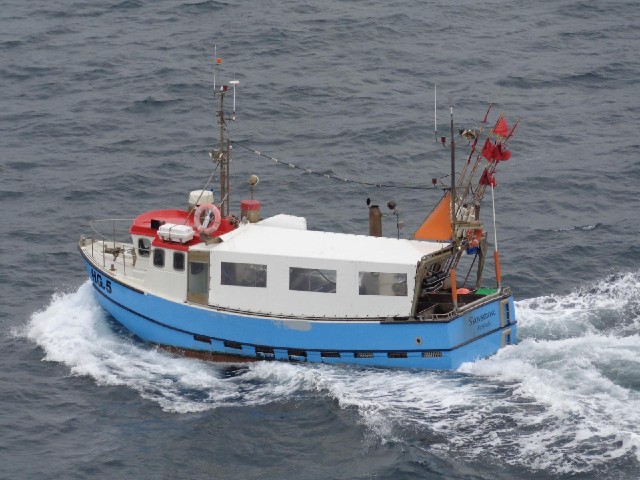 A small boat heading towards the harbour.