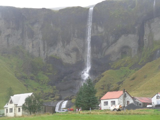 The two white stripes on the rock beyond the car are part of the waterfall.