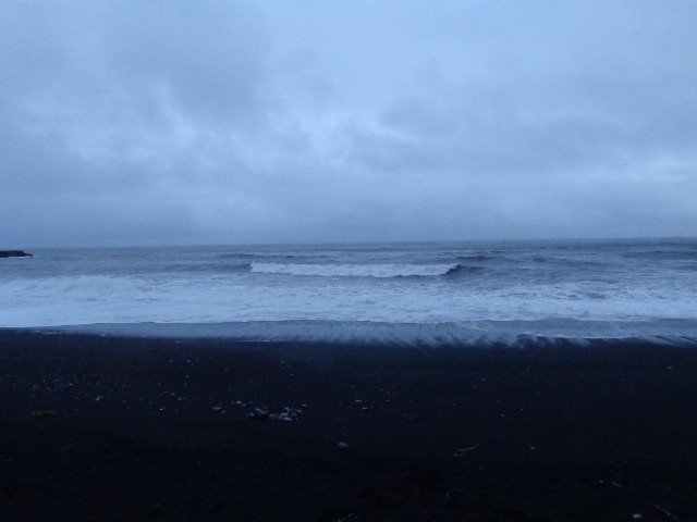 The stripey effect of the surf receeding across the black sand seems a bit spooky.