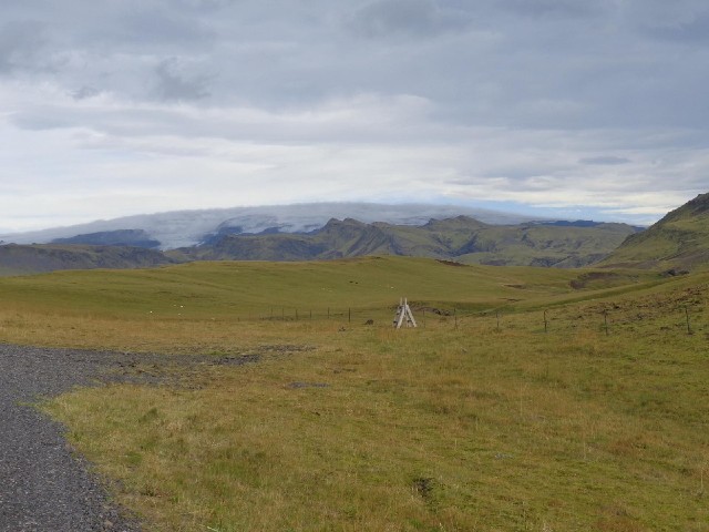 Scenery. The grey curved shape spanning the horizon is the Mrdalsjkull glacier.