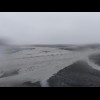 Water flowing across the black sand near Vik, with a pattern of standing waves....