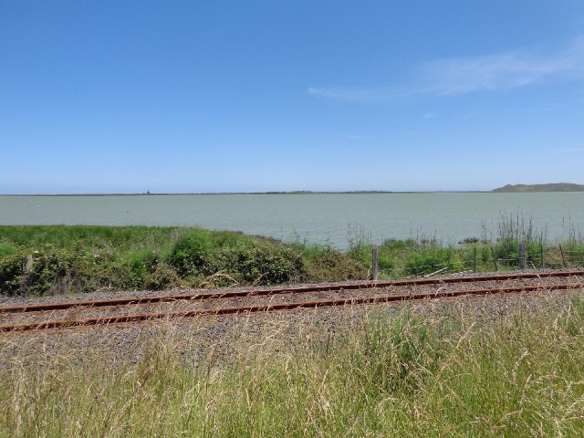 A green lagoon, in contrast to the sea which is bright blue today.