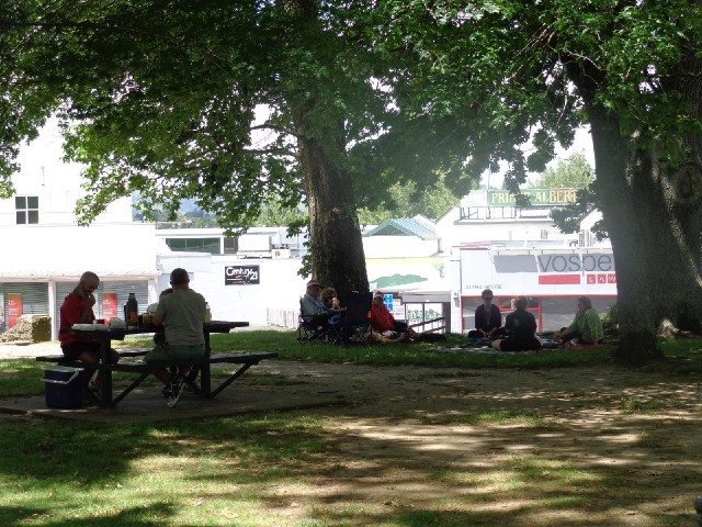 Picnickers in the park. There are several vans just out of the shot selling a variety of food but it...