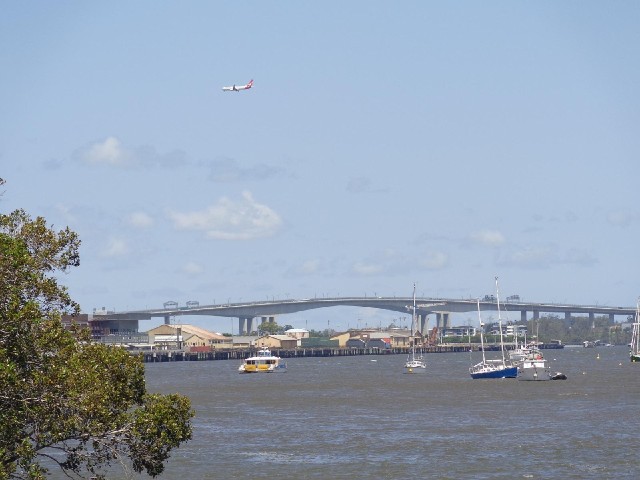 The Gateway Bridge with boats and a plane. I think the boat on the left is one of the ferries which ...