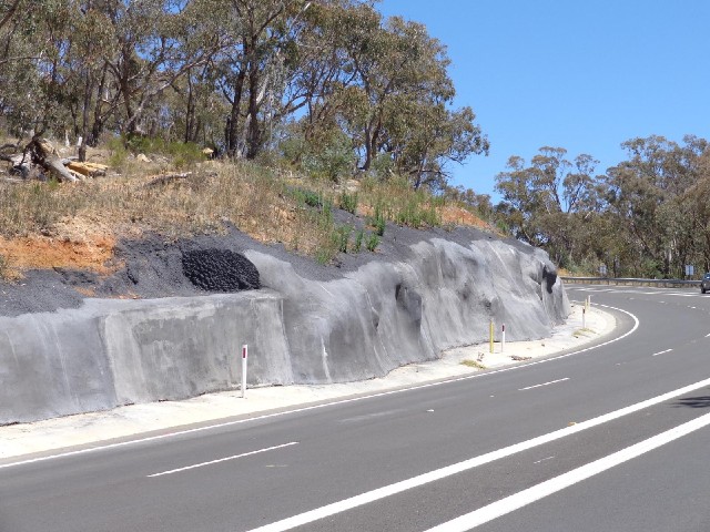 The rock which has been cut away to make room for the road seems to have been strangely polished.