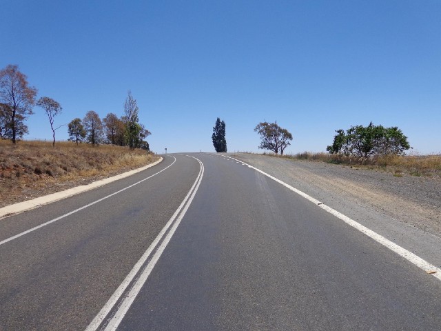 The road disappearing into the clear blue sky.