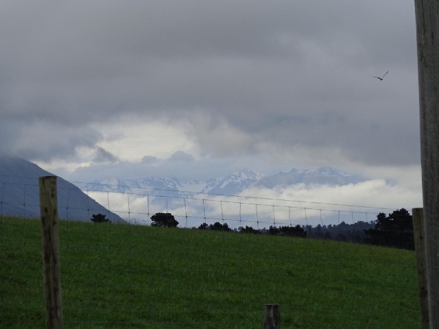 Snowy mountains just visible between the clouds.