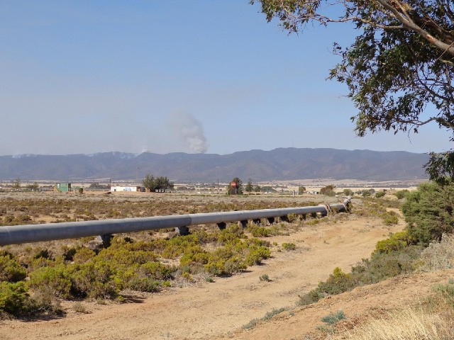 A pipe, with the smoke on the ridge in the background.