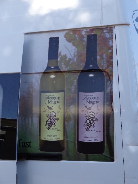 This is an advert for wine on the side of a van. It shows that magpies have the same reputation for ...