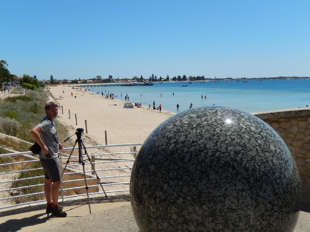 A photographer and one of those big freely-turning balls supported on water.