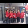 A chorus performing in the street. They might have been easier to hear if they had chosen to stand i...