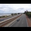 The Kwinana Freeway, with a railway line along the middle and a cycle lane along the far side.