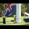 People trying to hoist a big flag.