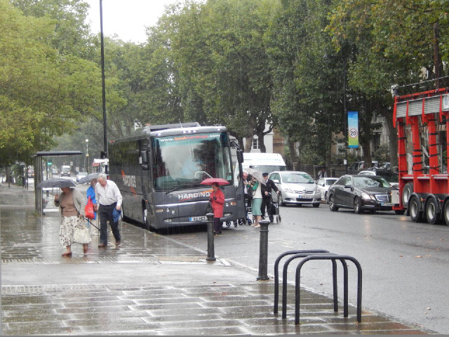 A coach party heading into the Imperial War Museum, while I shelter from the rain shower under a tre...