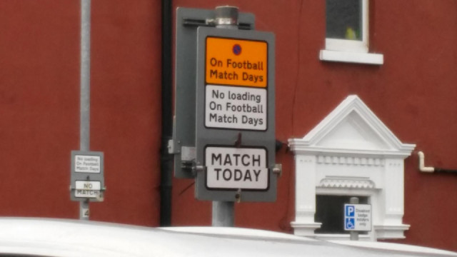 The signs on opposite sides of the road don't agree on whether there's a match today. There is, agai...