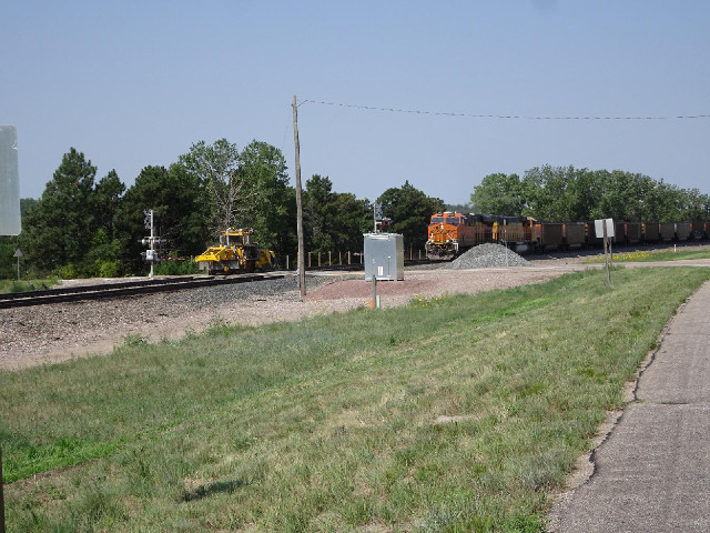 I think the little rail maintenance device on the left track had been waiting for this coal train to...