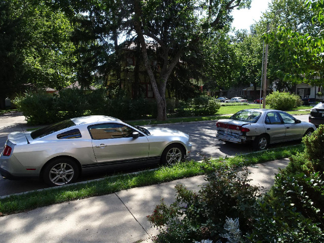 Outside my hotel today are a Mustang and a car with a smashed-in back bumper on which is written &qu...