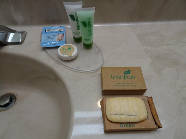 The round packet of soap is labelled "FACIAL BAR". The rear cardboard box is labelled &quo...