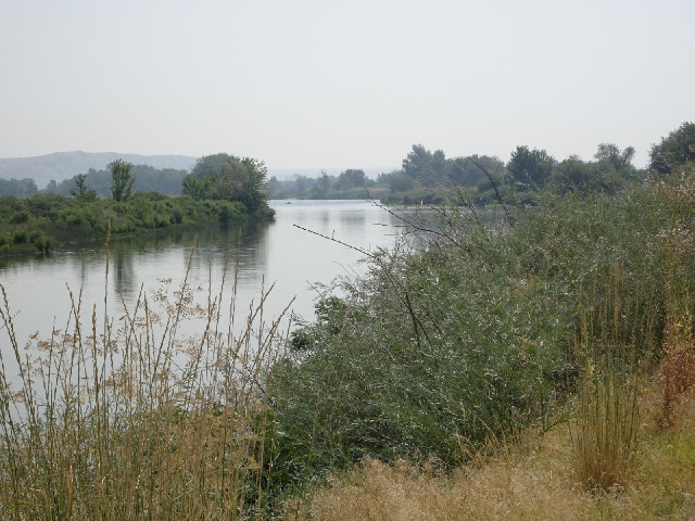 The Payette river. In the distance is a man in an inflatable boat.