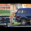 These people are having a barbecue on the tailgate of their vehicle in the hotel car park. They are ...