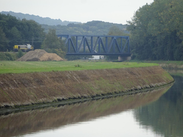 A lone locomotive approaching a bridge.