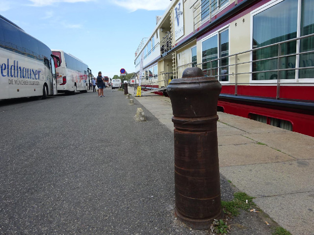 This is either an old cannon or a replica of one. You can see where boats' mooring lines have worn a...