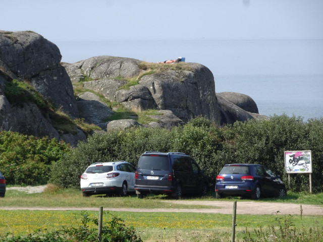 There's a man sunbathing on top of the rocks.