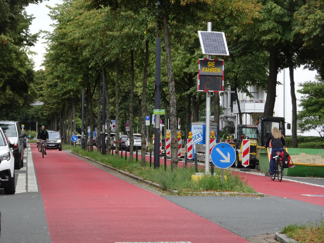 This road is painted pink and has many signs saying that it's a bicycle road, and just a few other l...