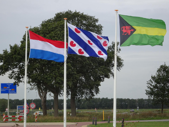 The flags of the Netherlands, Friesland province and the village of Donkerbroek.