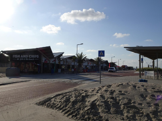 Seaside buildings, next to a notice board about the Rhine cycle route, which must end very near here...