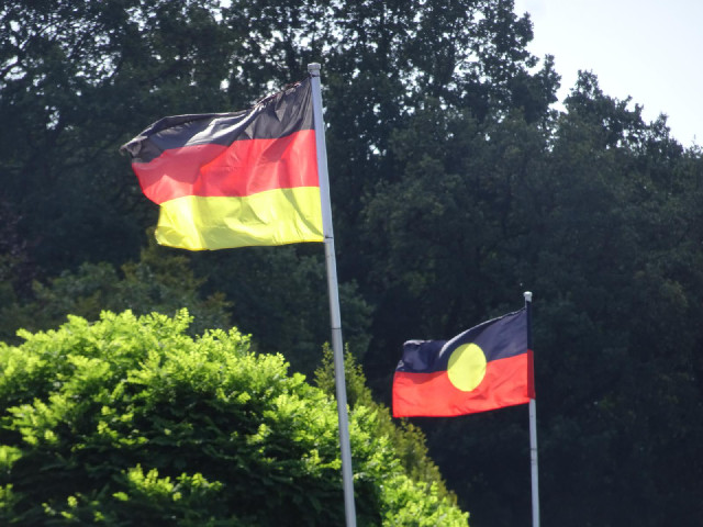 The German flag and the Australian Aboriginal flag flying outside a restaurant.