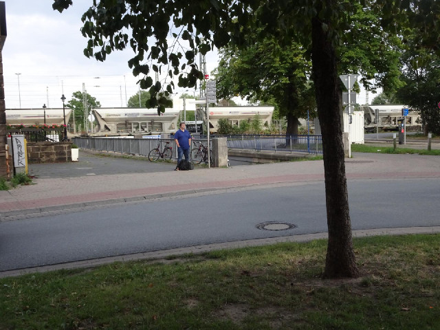 My bike is parked over there by the station, where what looks like a coal train is currently going p...