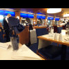 Each table in the restaurant is decorated with a blue paper napkin which has been made to resemble a...