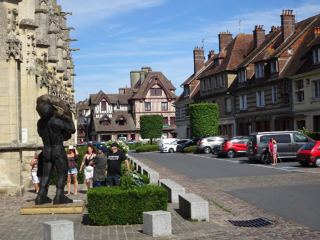 Pont l'Eveque, with a statue of what looks like a man carrying a large rock.