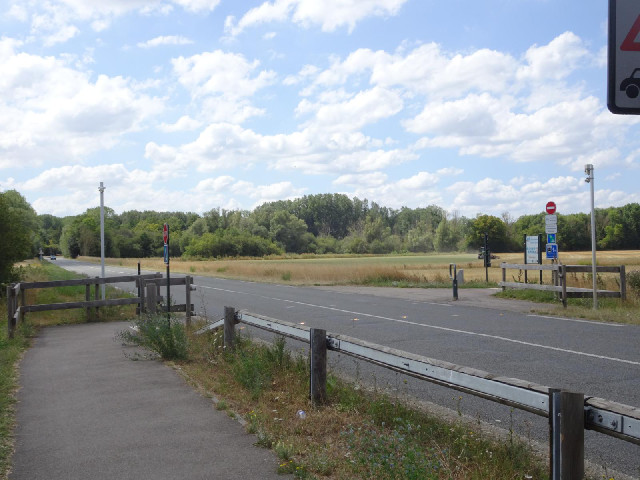 In this area, where a bike path crosses a road, there are orange studs in the road which flash whene...