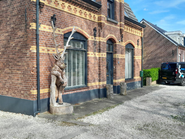 A wood carving of a bored deer.