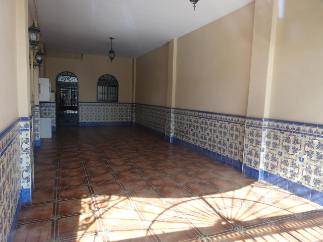 A vacant shop with tiled walls and floor.