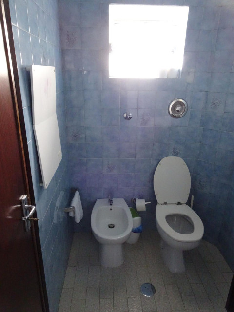 The bathroom has some odd features. The panel on the left appears to be an electric radiator but it'...