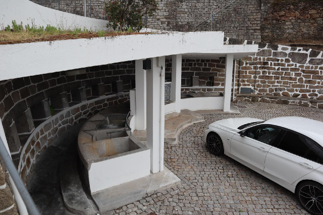 There's an array of stone sinks, one of which has water gushing into it.