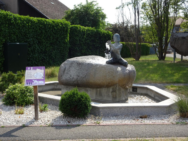 The sign says that this fountain is meant to represent water springing forth from a woman's hands bu...