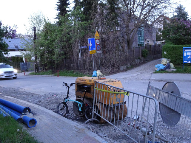 I've found the sign. It's a bit overgrown but I can rest my camera on that road roller to keep it st...