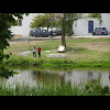 Children fishing in a pond. Also, a very strange car.