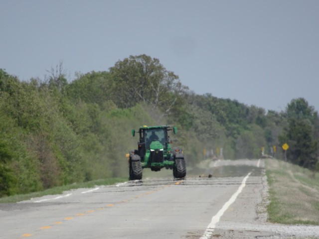This tractor is sort of ploughing the field next to the road but it's doing it in a very strange way...